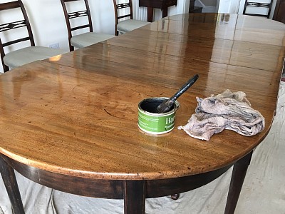 Polishing a dining table with beeswax.